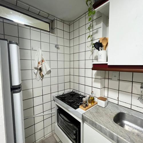 a kitchen with a stove and a sink at Apt Areia e Maré in Maceió