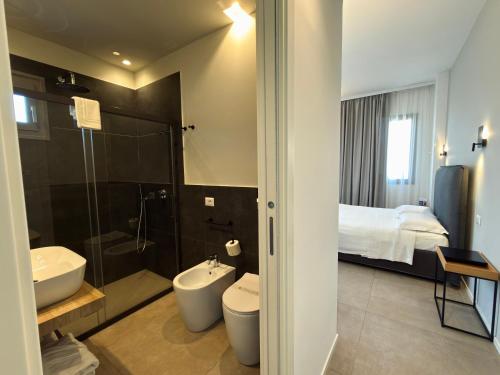 ein Badezimmer mit Waschbecken, Toilette und Bett in der Unterkunft Baglio Custera in Marsala