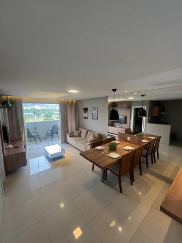 a large living room with a table and a couch at LRFlat - Ambiente climatizado, moderno, confortável e próximo a tudo! in Montes Claros
