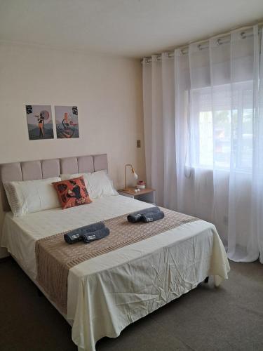 a bedroom with a bed with two towels on it at Apartamento em Pelotas Centro in Pelotas