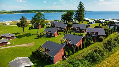 an aerial view of a farm with houses and the water at Vikær Strand Camping & Cottages in Diernæs