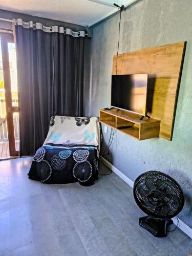 a bedroom with a bed and a mirror and a chair at Casas Container Cassino in Rio Grande