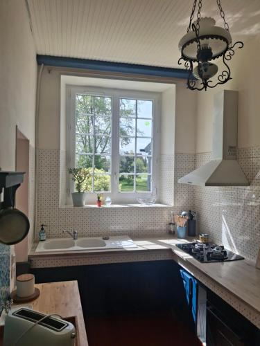a kitchen with a sink and a window at Gîte de la Ferme Feugère in Barbeville