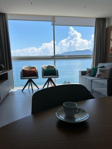 a coffee cup sitting on a table in a living room at Vilella Vista Bela in Angra dos Reis