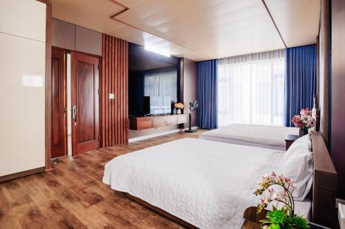 a bedroom with a large bed and a television at BEN Villa in Cẩm Phả Mines