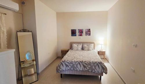a small bedroom with a bed and a mirror at צימר החורש in Dāliyat el Karmil