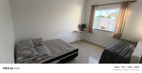 a small bedroom with a bed and a window at Aconchegante in São Mateus