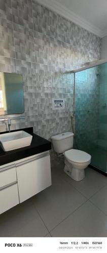 a bathroom with a toilet and a sink and a shower at Aconchegante in São Mateus