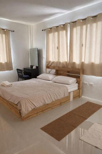 a bedroom with a large wooden bed with a desk at blissful well treat in Ban Madua Wan