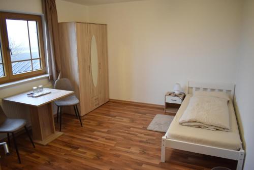 a bedroom with a bed and a table and a window at Monteurzimmer, Gästezimmer, Ferienwohnung in Altötting