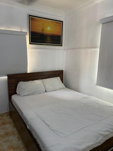 a bed in a bedroom with a picture on the wall at Beulah House Lounge in Ibadan