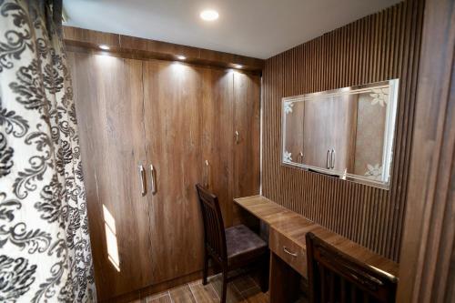 a home office with wooden cabinets and a chair at Hotel Asian Comfort in Srinagar