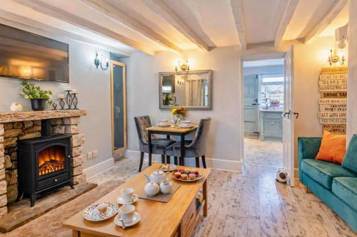 a living room with a fireplace and a green couch at Charming Shepherd's Cottage, Pets Welcome,Parking in Bridgend