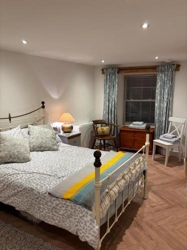 a bedroom with a bed and a desk and a chair at Ship Cottage Tenby Beach 50m in Pembrokeshire
