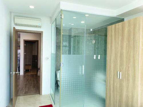 a shower in a bathroom with a glass door at Ocean Dream Apartment Nha Trang in Nha Trang