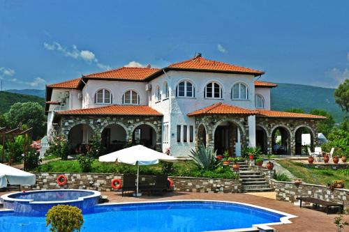 a large house with a swimming pool in front of it at Zeus Hotel in Platamonas