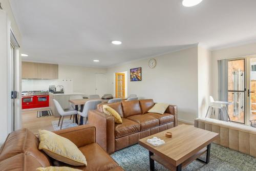 a living room with a couch and a table at Elysian Fields in Joondalup in Perth