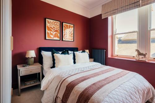 a red bedroom with a bed and a window at St James Apartments - Harrogate in Harrogate