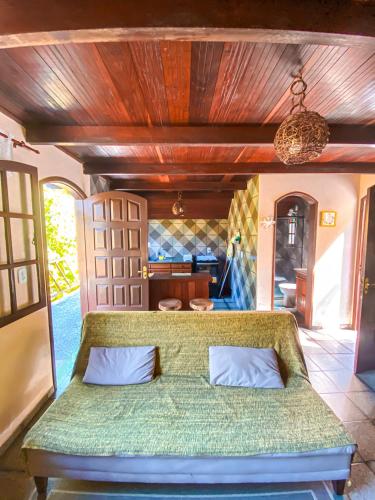 a bedroom with a green couch in a room at Chalé Espaço Raiz de Lumiar in Nova Friburgo