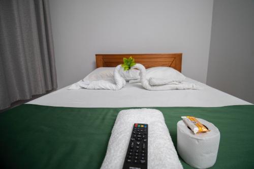 a bed with towels and a remote control on it at Hospedaje Humazapa in Tarapoto