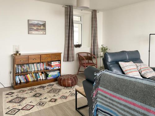 a living room with a couch and a book shelf at Machermore Cottage in Gillespie