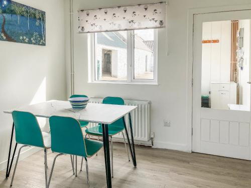 a dining room with a white table and chairs at Machermore Cottage in Gillespie