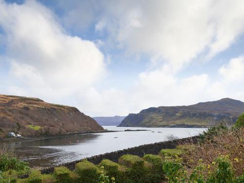 a body of water with mountains in the background at Cornucopia in Portree