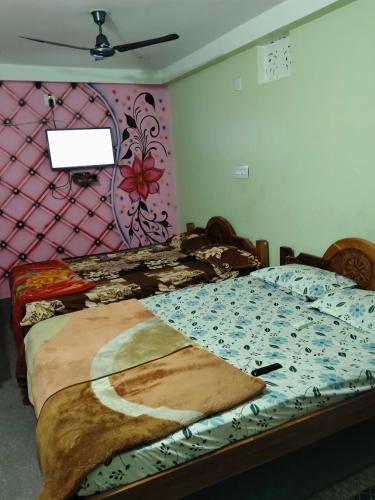 a bedroom with two beds and a pink wall at Haramani Guest House in Konārka