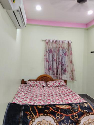a bedroom with a bed with a quilt on it at Haramani Guest House in Konārka