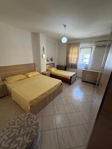 a hotel room with two beds and a window at Aldi APARTMENTS in Lezhë