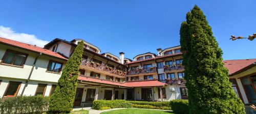 a large building with trees in front of it at Evelina Palace Hotel in Bansko