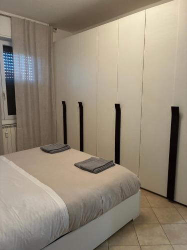 a bedroom with a bed with white cabinets and a window at Fabio Filzi 32 sub 7 in Lainate