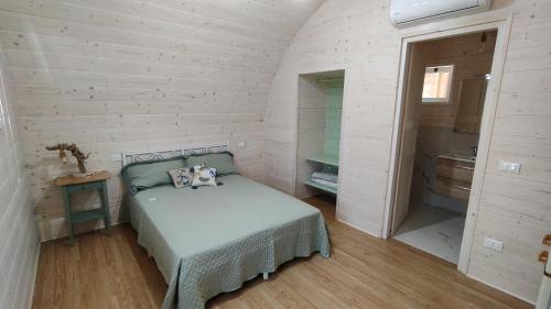a small bedroom with a bed and a bathroom at Camping Luni in Marina di Massa
