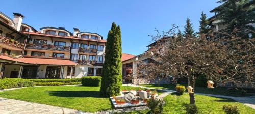 a hotel with a garden in front of a building at Evelina Palace Hotel in Bansko