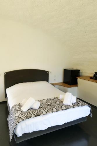 a bed with two pillows on it in a room at Motel l'eau vive in Raon-lʼÉtape
