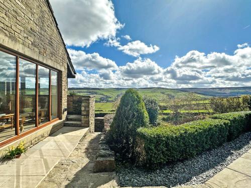 a house with a view of the rolling hills at Shelduck Cottage in Holmfirth