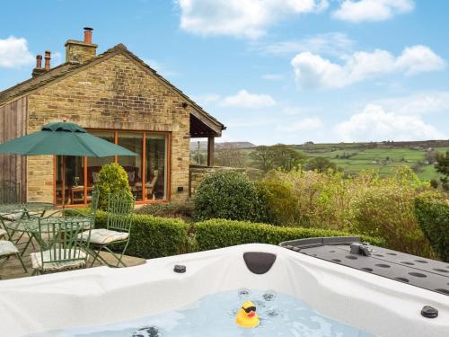 a hot tub in the backyard of a house at Shelduck Cottage in Holmfirth