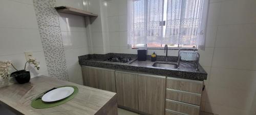 a kitchen with a sink and a counter with a plate on it at Residencial Hanna in Anápolis