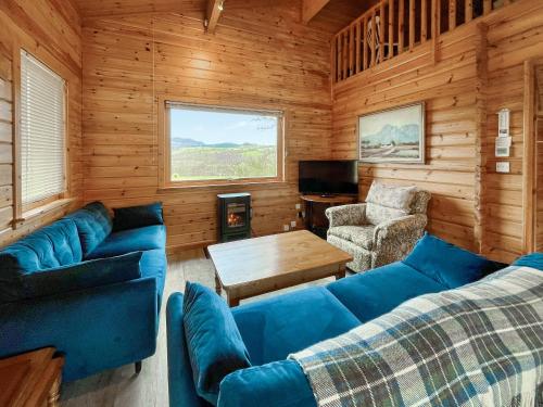 a living room with blue couches and a table at Whiteburn in Pitlochry