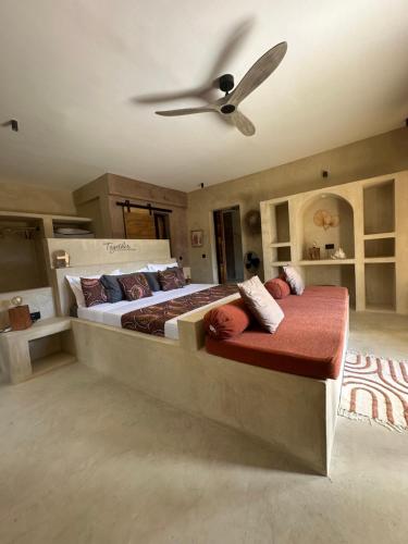 a bedroom with two beds and a ceiling fan at Uroa Sunset Bliss in Uroa