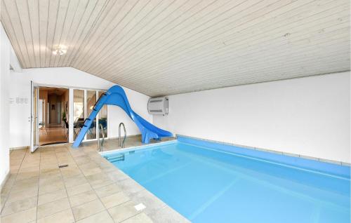 an indoor swimming pool with a slide in a house at Nice Home In Hvide Sande With Sauna in Hvide Sande