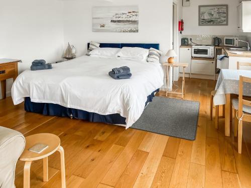 a bedroom with a large bed and a kitchen at The Sail Room in Saint Mawes