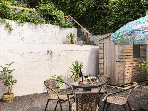 a patio with a table and chairs and a fence at Brynhafod in Llanfihangel-geneuʼr-glyn
