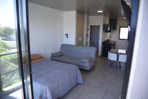 a bedroom with a bed and a couch and a table at Tigre-Estación Fluvial Monoambiente in Tigre