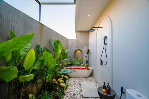a bathroom with a bath tub and plants at Casa Ariana in Ubud