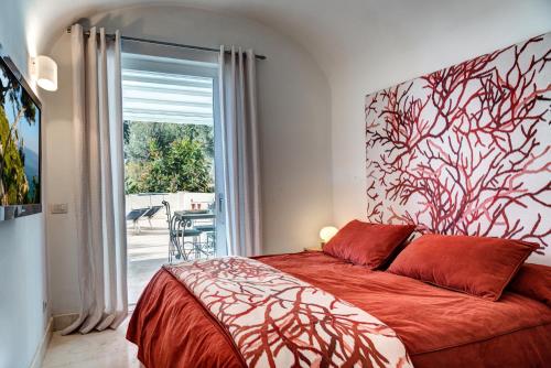 a bedroom with a red bed with a large window at GOCCE VILLAS - Villa Bouganvillea Superb Capri Villa with Views in Capri