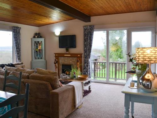 a living room with a couch and a fireplace at Timbers in Woolfardisworthy