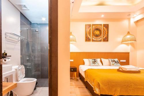 a bedroom with a bed and a shower and a bathroom at Infinity Bay Suites in Puerto Galera