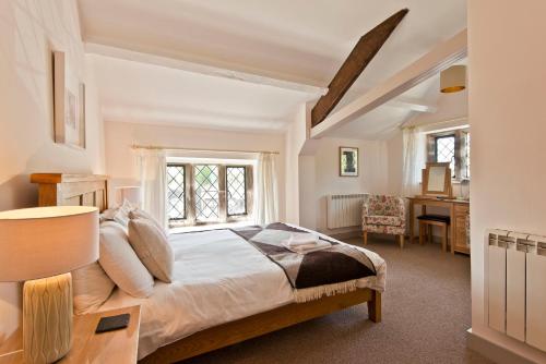 a bedroom with a bed with a desk and a window at Swarthmoor Hall in Ulverston