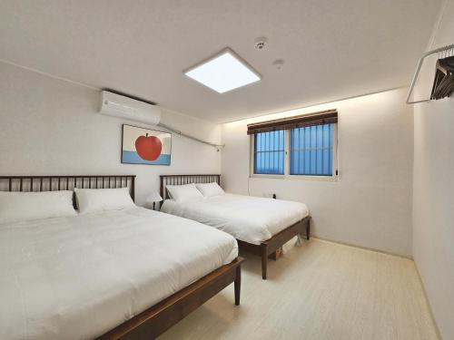 a bedroom with two beds and a window at Check in Seoul in Hongdae 2 in Seoul